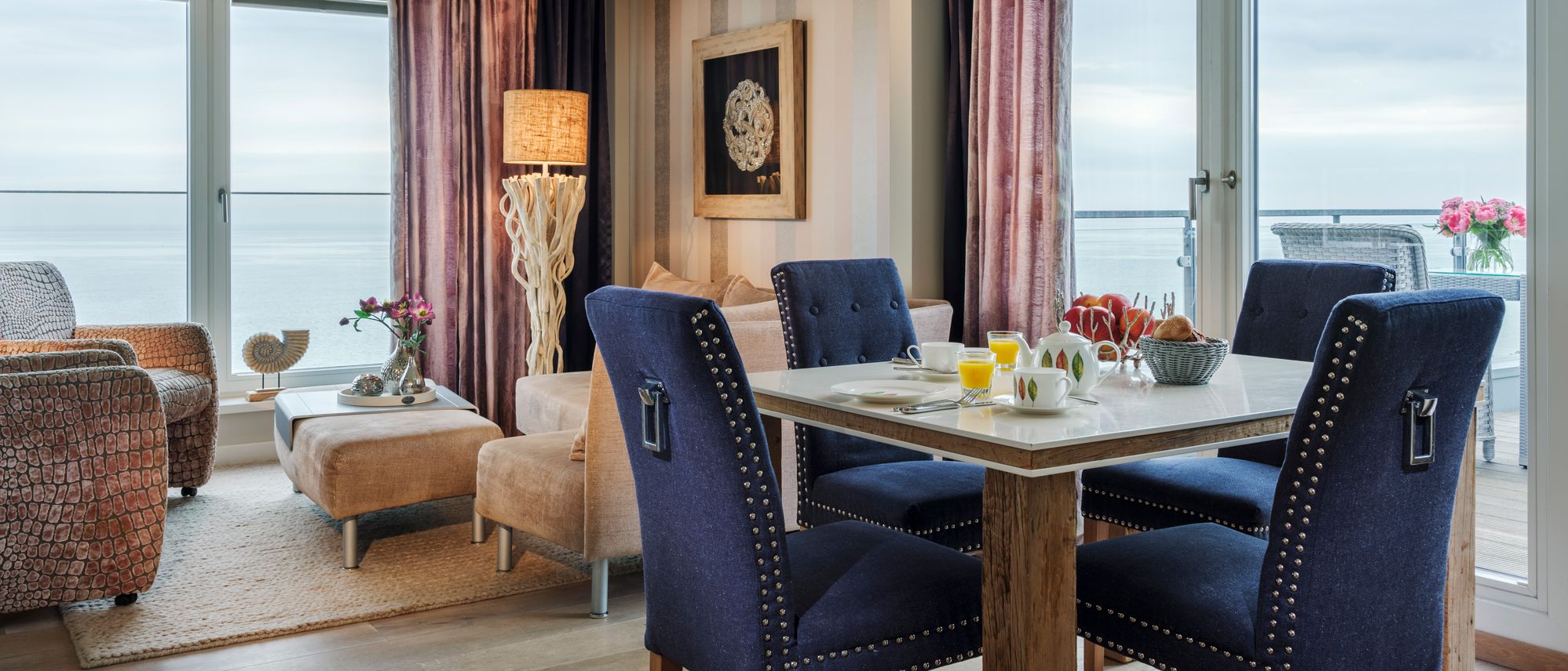 Helles Zimmer mit Couchecke, Esstisch und großem Balkon